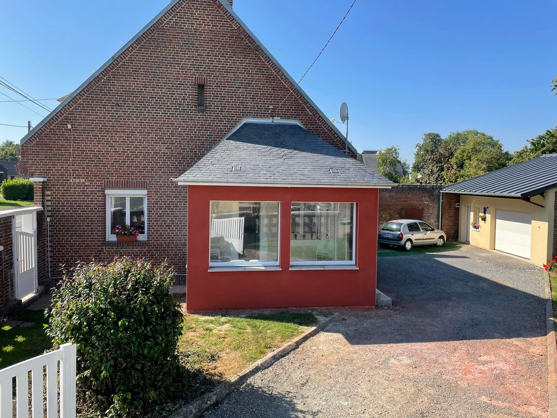 Une extension de maison avec un enduit rouge