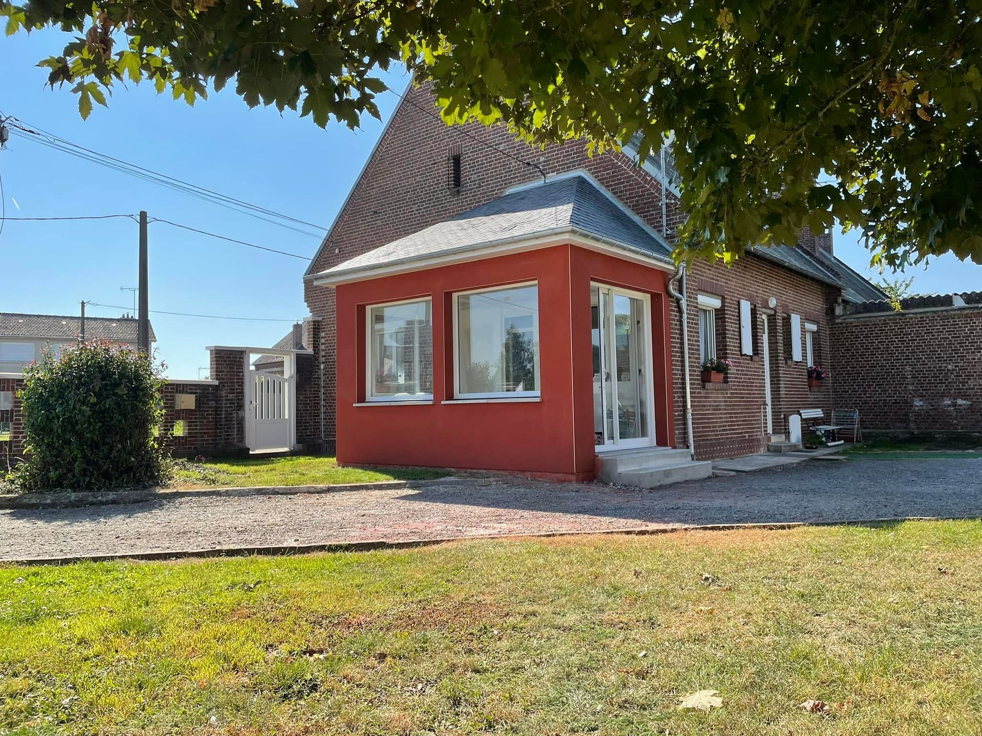 Une extension latérale de maison avec un enduit rouge brique