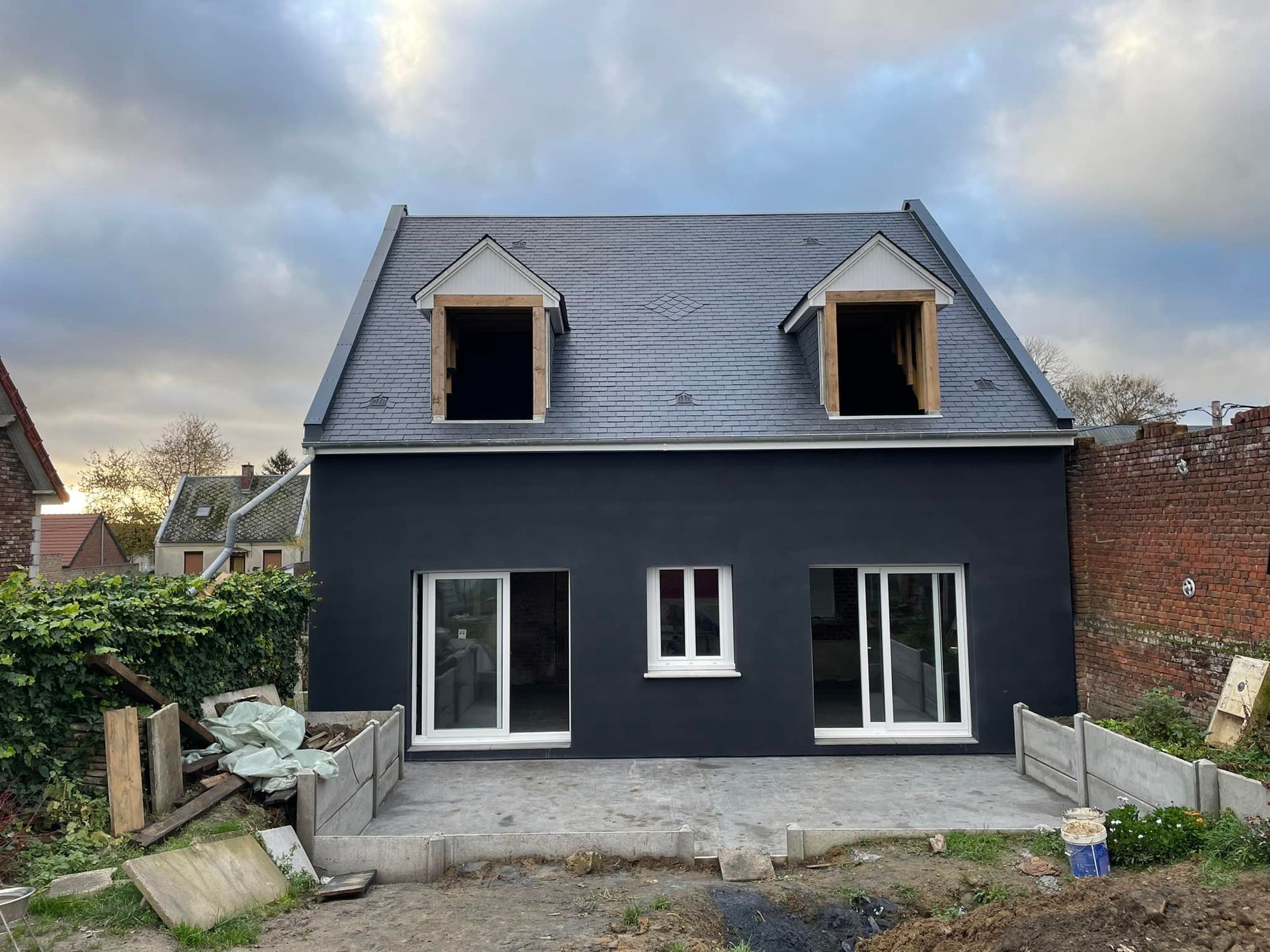 Une maison avec la façade enduite en noir