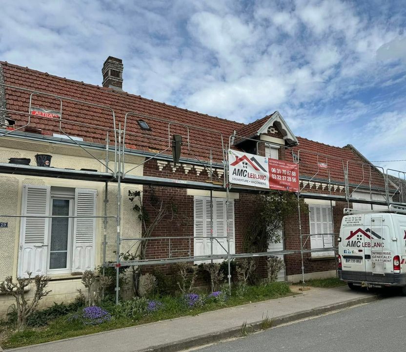 Une façade avec un échafaudage et le camion du professionnel garé devant