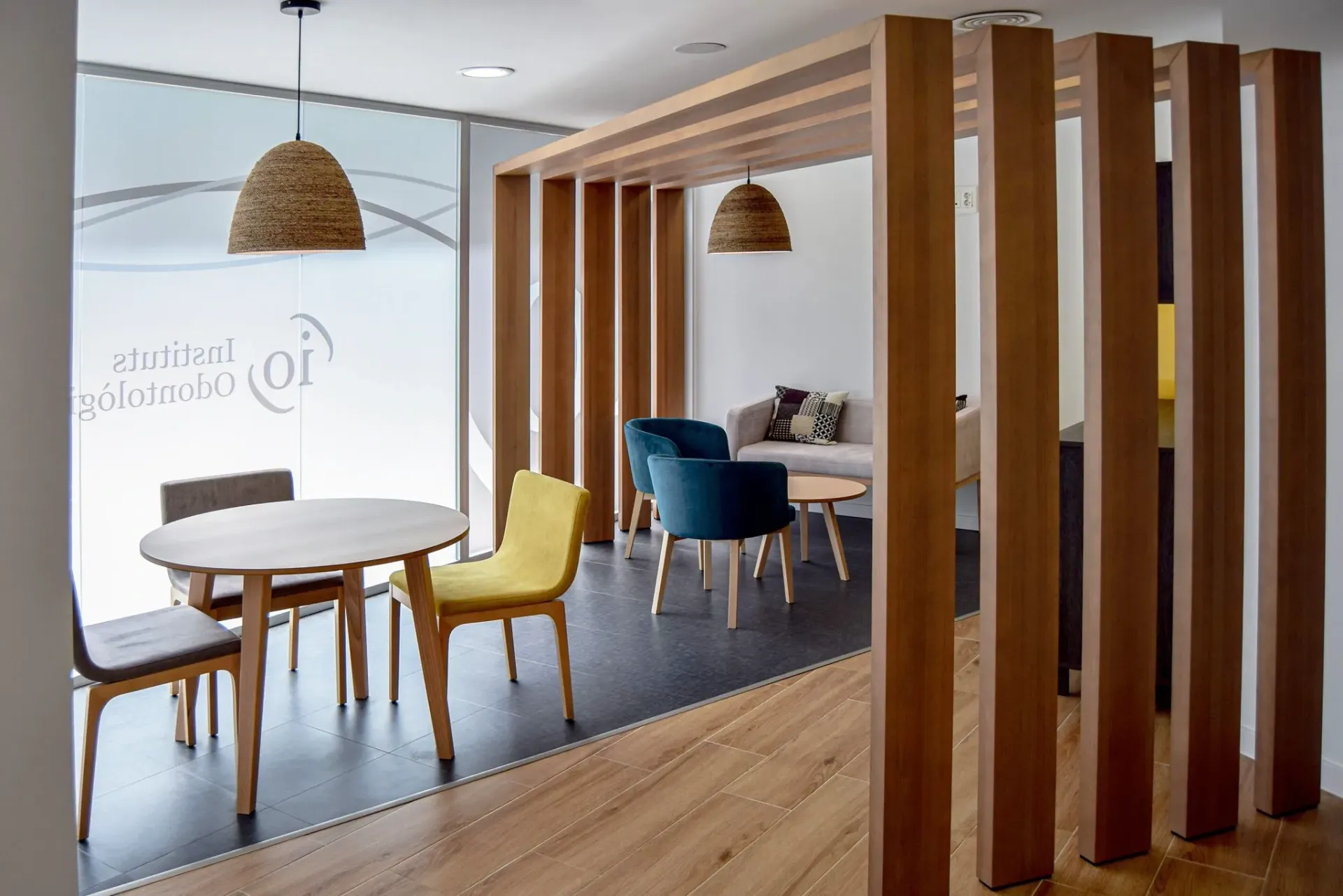 Moderna sala de espera de oficina con divisor de madera, mesas y sillas.