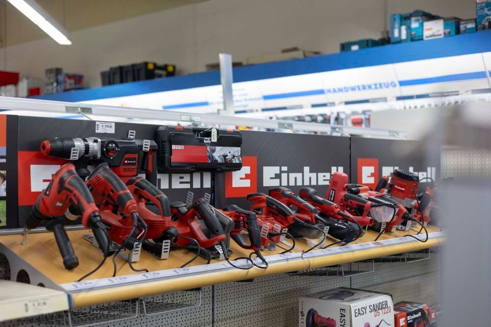 Rote Elektrowerkzeuge der Marke „Einhell“ stehen in einem Baumarkt auf dem Display.