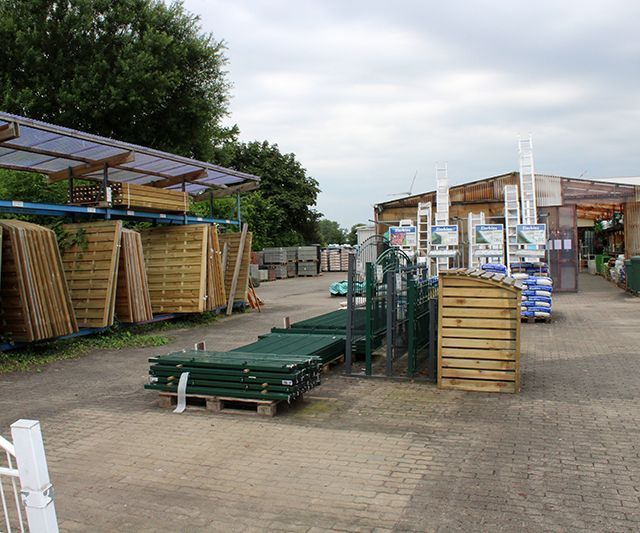 Auf einem Hof ​​sind viele Holzpaletten übereinander gestapelt.