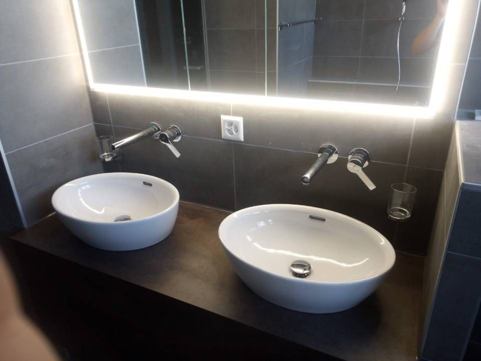Une salle de bain avec deux lavabos et un miroir