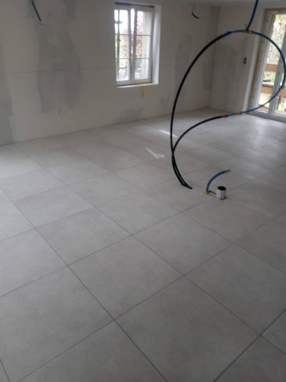 Un sol carrelé blanc dans une pièce avec une fenêtre