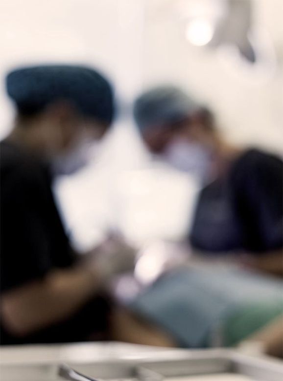 Una imagen borrosa de dos cirujanos operando a un paciente.