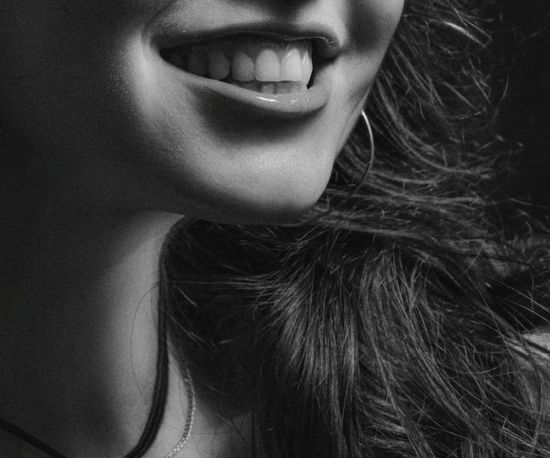 Una mujer sonríe en una foto en blanco y negro.