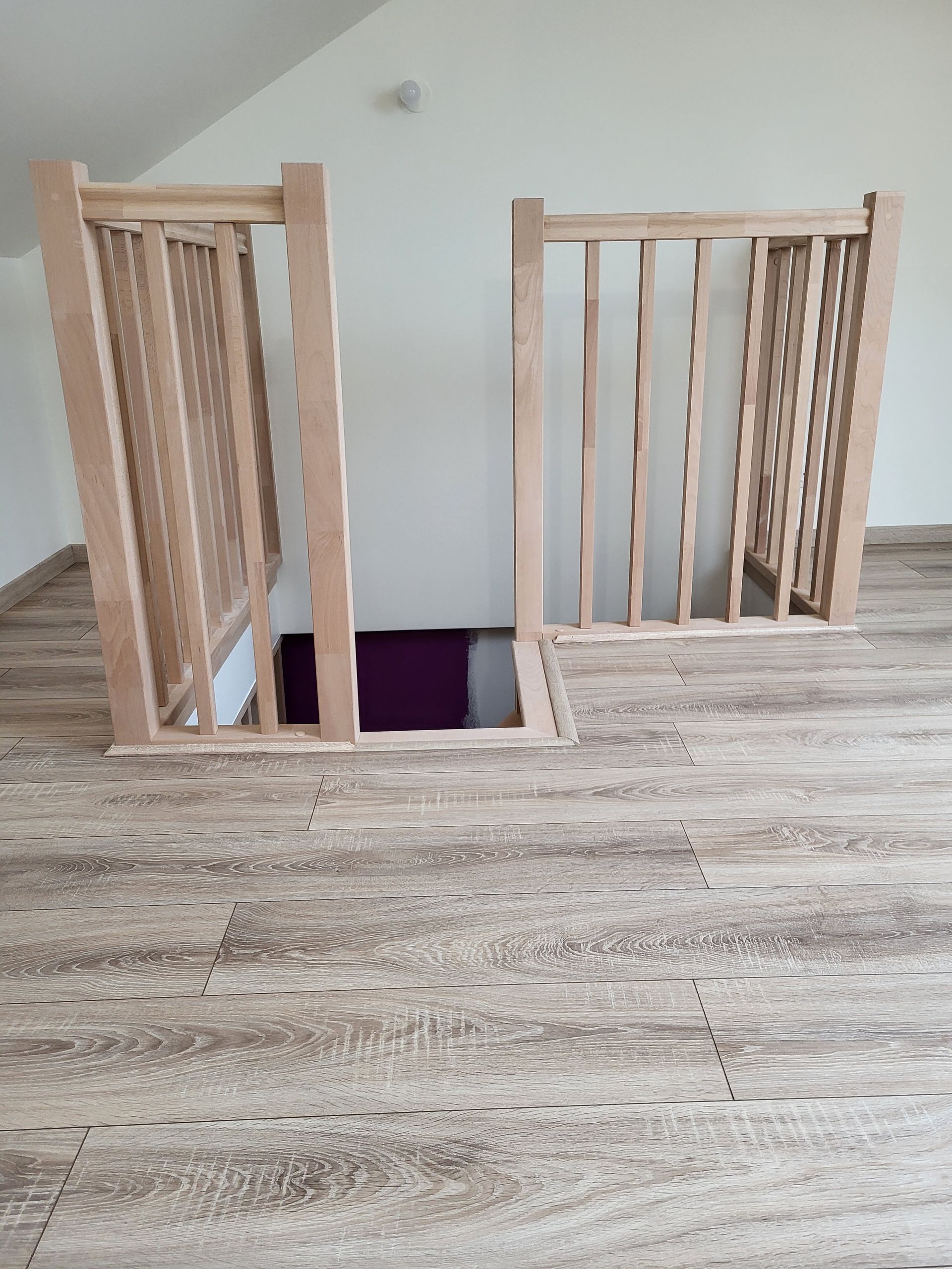 Sol en parquet devant une rampe d'escalier