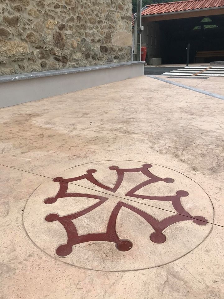 Moule croix occitane sur la place du village d' Amplaing.