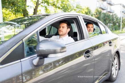 Zwei Männer sitzen in einem Auto und schauen aus dem Fenster. Mietwagen Gemünden