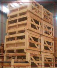 Cajas de madera apiladas en un almacén, posiblemente para almacenamiento o envío.