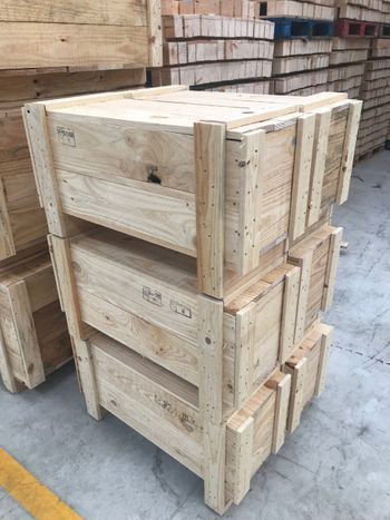 Cajas de madera apiladas sobre un suelo de hormigón, en un almacén.