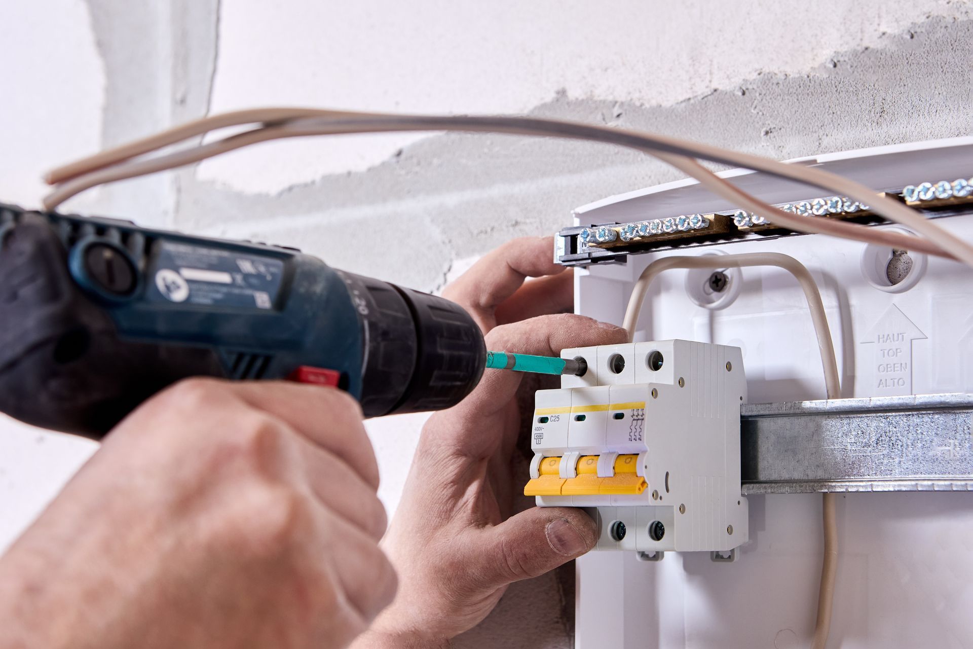 Un monsieur réfectionne l'installation électrique dans les normes de sécurité