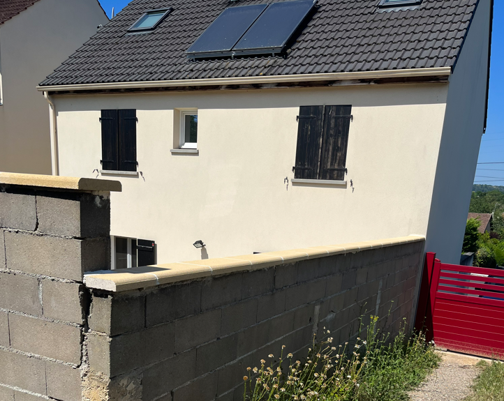 Maison beige avec mur en pierre gris