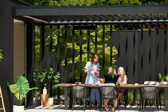 Pergola auf einer Terrasse mit Lamellenwand