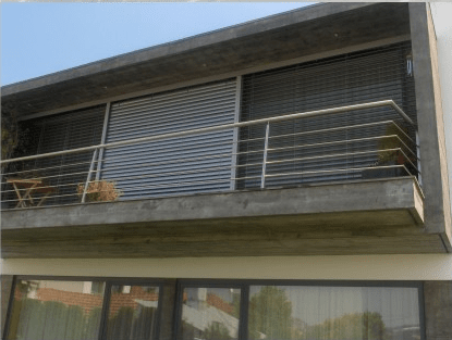 Uma varanda com corrimão de aço inoxidável na lateral de um prédio