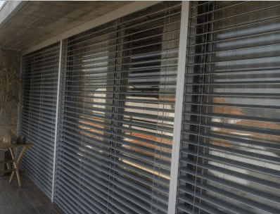 Uma fileira de portas de vidro deslizantes com persianas.