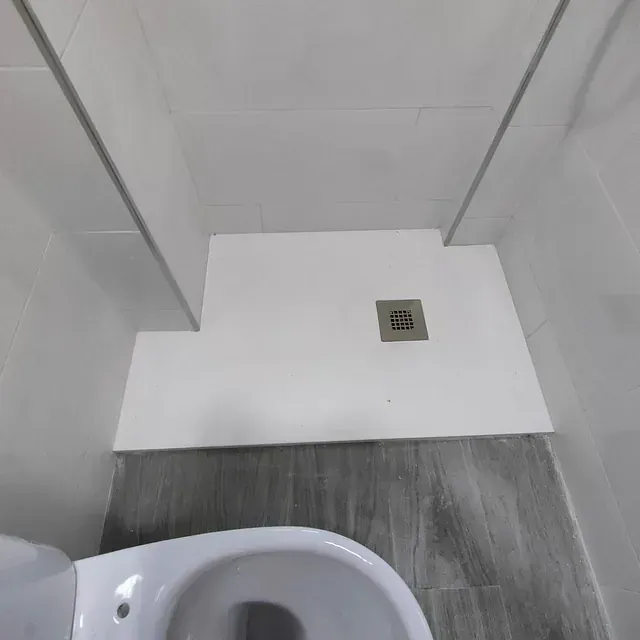 Un baño con inodoro y cabina de ducha.