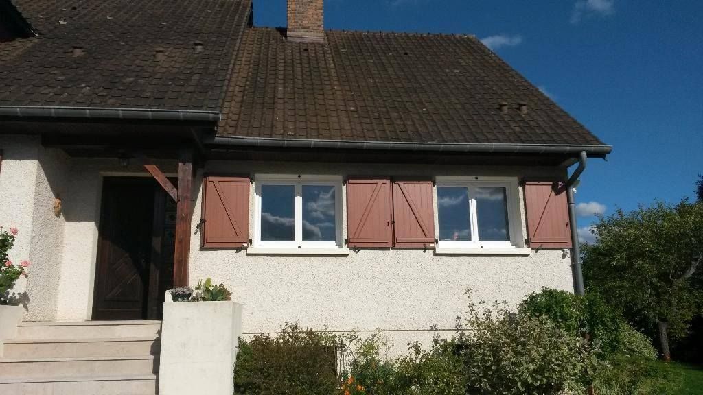 Deux fenêtres blanches avec volets marrons