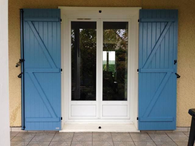 Portes-fenêtres blanches avec volets bleus