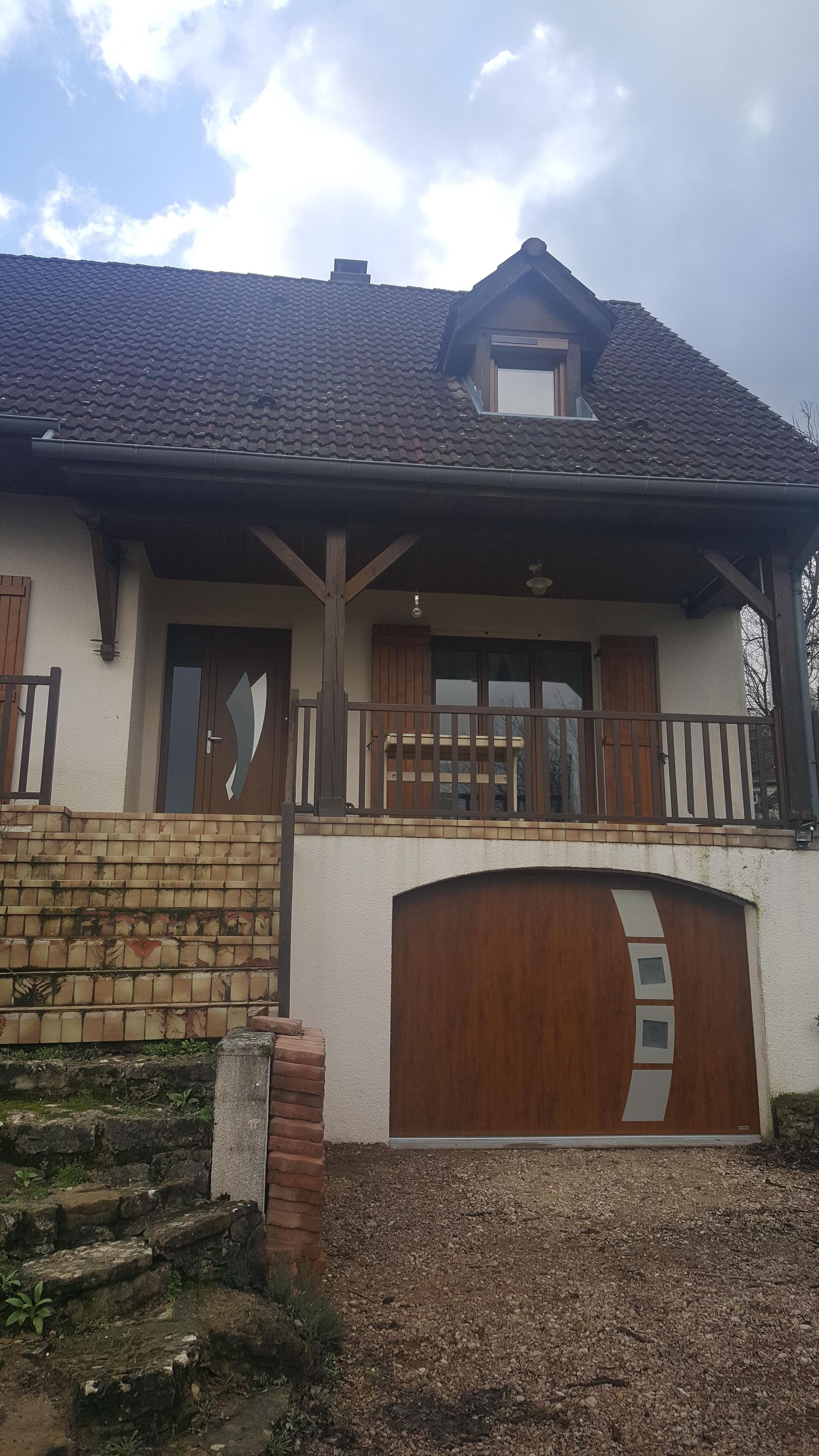 Porte de garage en bois avec vue sur l'entrée de la maison