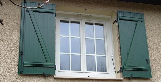 Fenêtre blanche avec volets verts