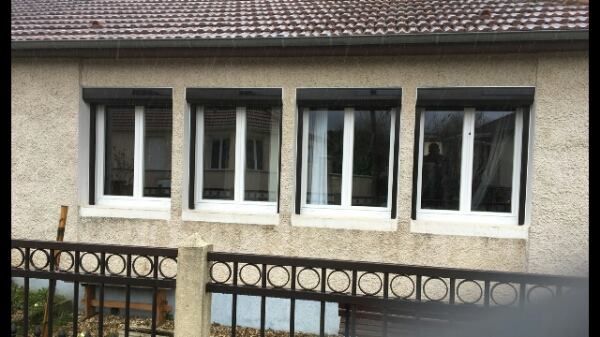 Quatre fenêtres blanches avec volets roulants gris anthracite