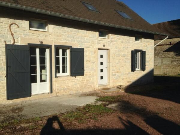 Maison en pierre avec portes et fenêtres blanches et volets gris anthracite
