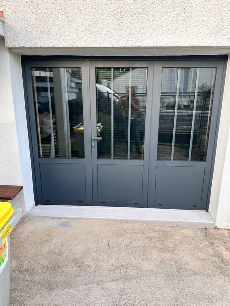 Grande baie vitrée gris anthracite avec une porte au centre