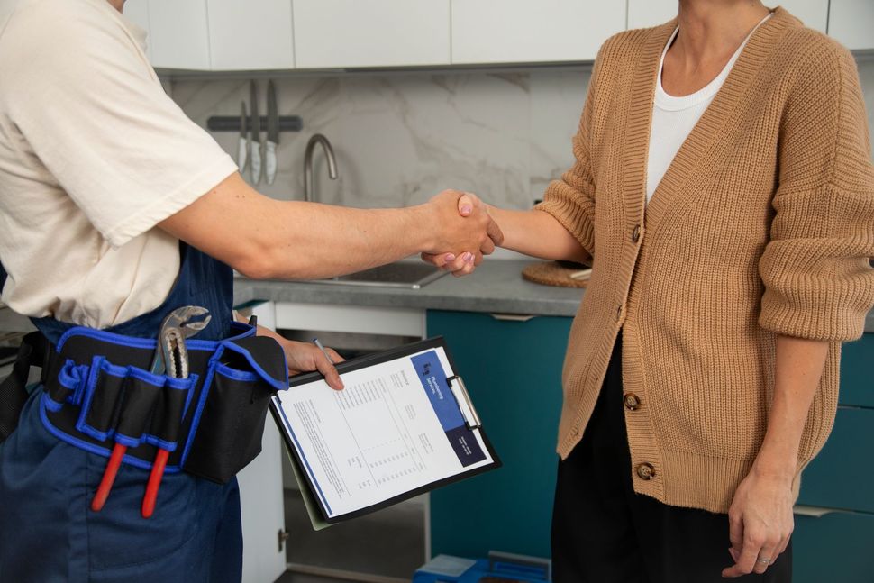 Un técnico estrechando la mano de un cliente tras finalizar un trabajo.