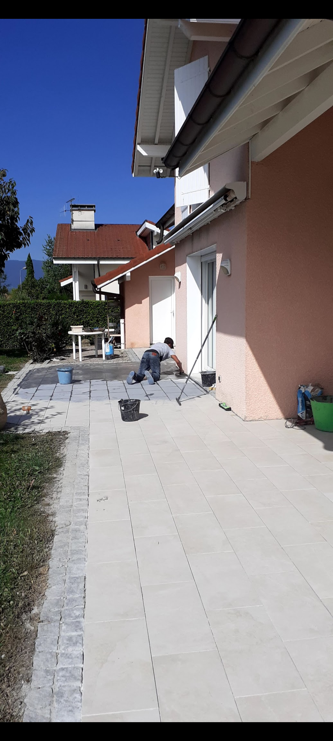 Intérieur de bureau vide avec parquet en bois clair, cloisons en verre et blanches et débris de construction.