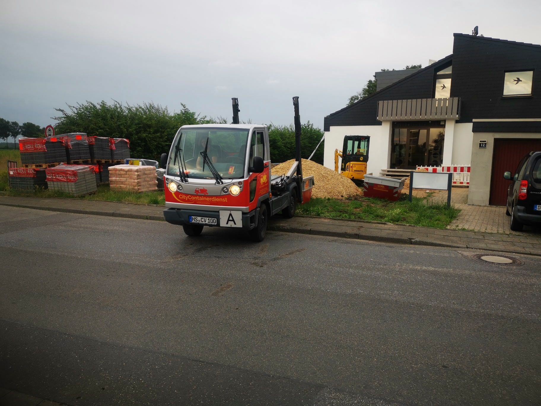 Ein LKW mit einem Nummernschild, auf dem steht, dass er vor einem Haus geparkt ist