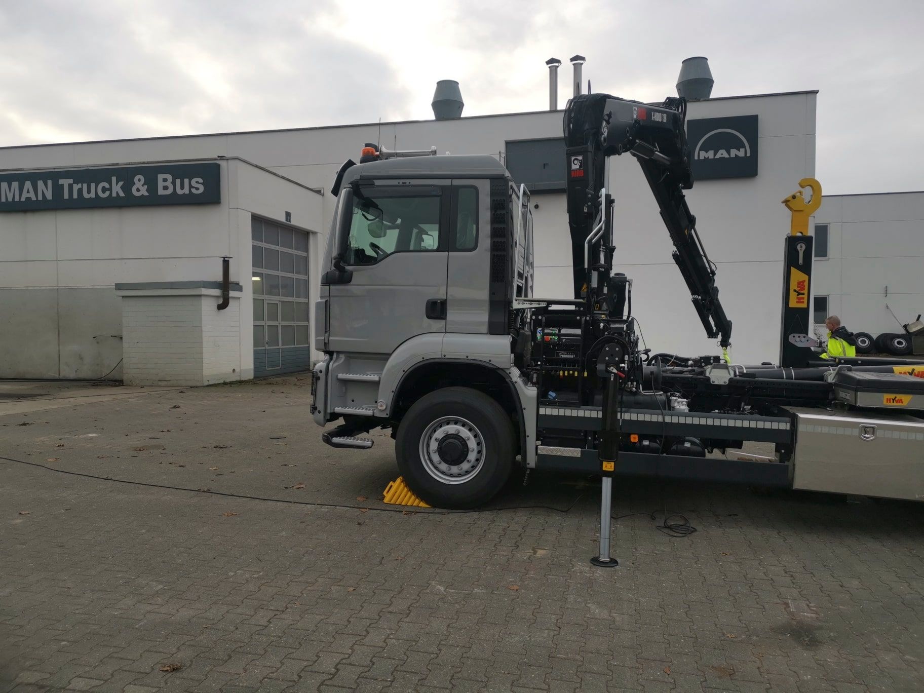 Ein MAN-LKW steht vor einem Gebäude mit der Aufschrift „MAN Truck & Bus“