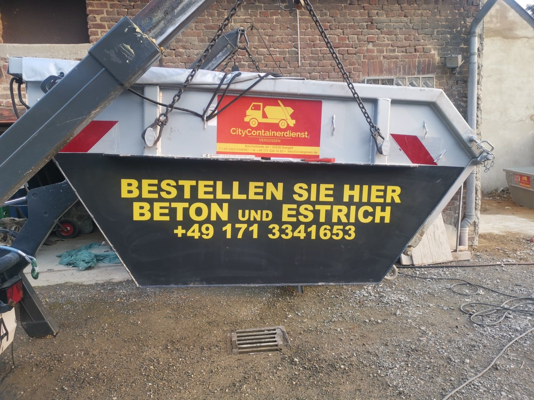 A dumpster that says ' bestellen sie hier beton und estrich ' on it