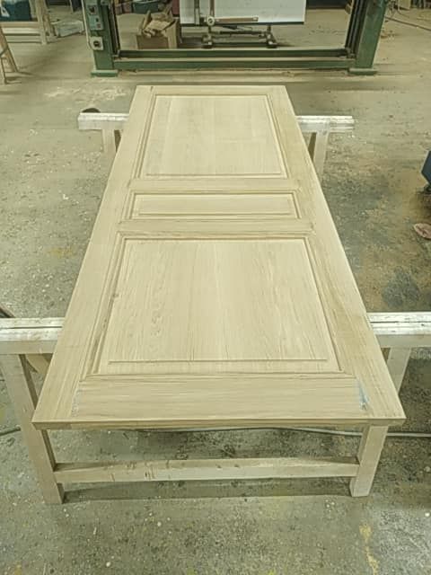 Porte posée à plat sur tréteaux, en cours de fabrication