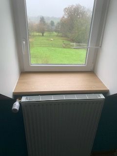 Gros plan sur une tablette en bois devant une fenêtre