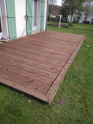 Travaux de terrasse bois terminés, maison aux volets verts
