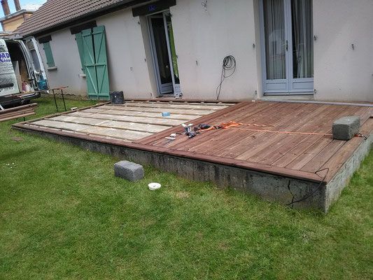 Façade de maison aux volets verts, suite des travaux de pose de terrasse bois et finition