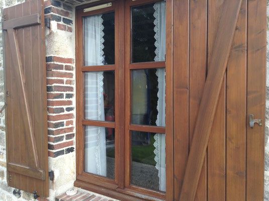 Fenêtre en bois foncé avec volets