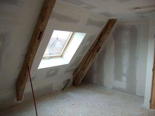 Espace sous combles, fenêtre de toit et poutres apparentes