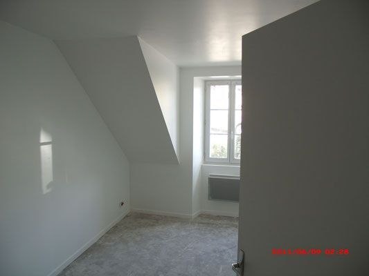 Chambre rénovée et isolée, vue sur mur, sol et fenêtre