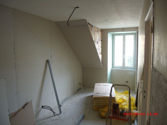 Chambre à rénover et à isoler, vue sur mur, sol et fenêtre