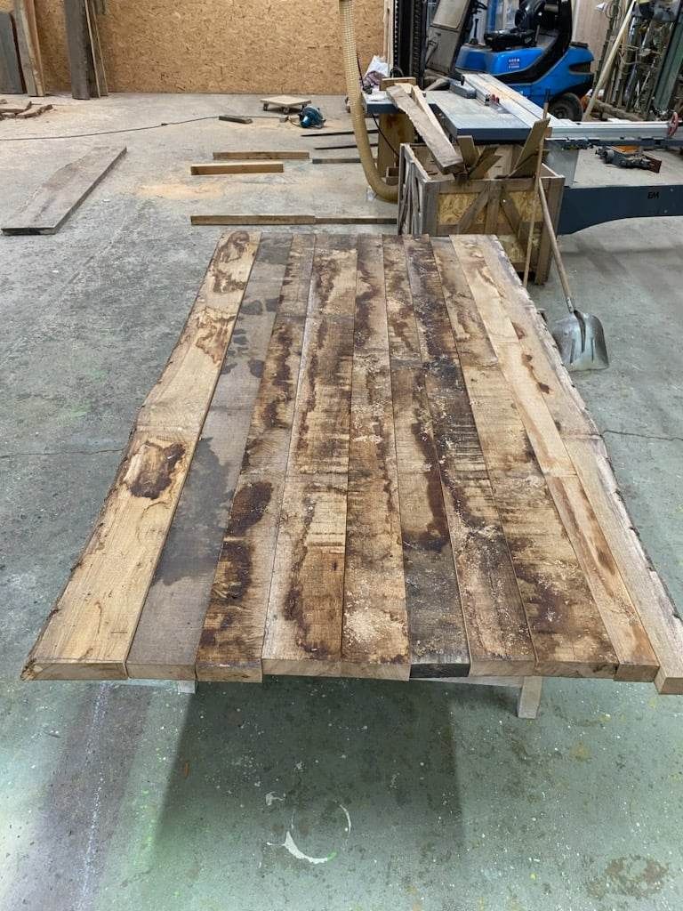 Lames de planches de bois brutes assemblées pour fabriquer une table