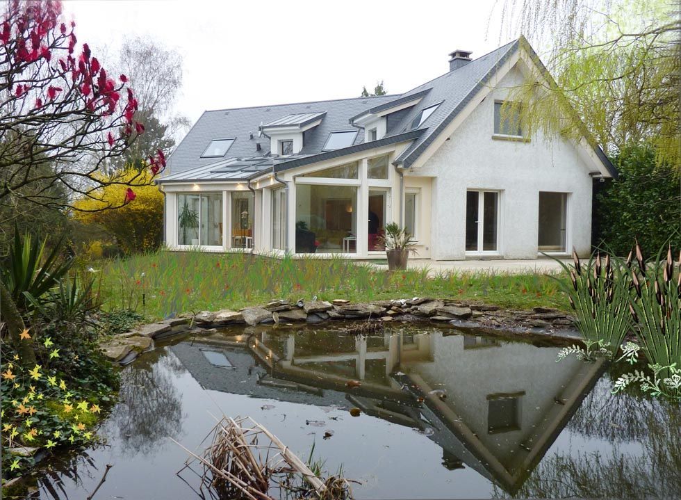 Maison blanche au toit gris et à la partie vitrée, se reflétant dans un étang. Ambiance printanière.
