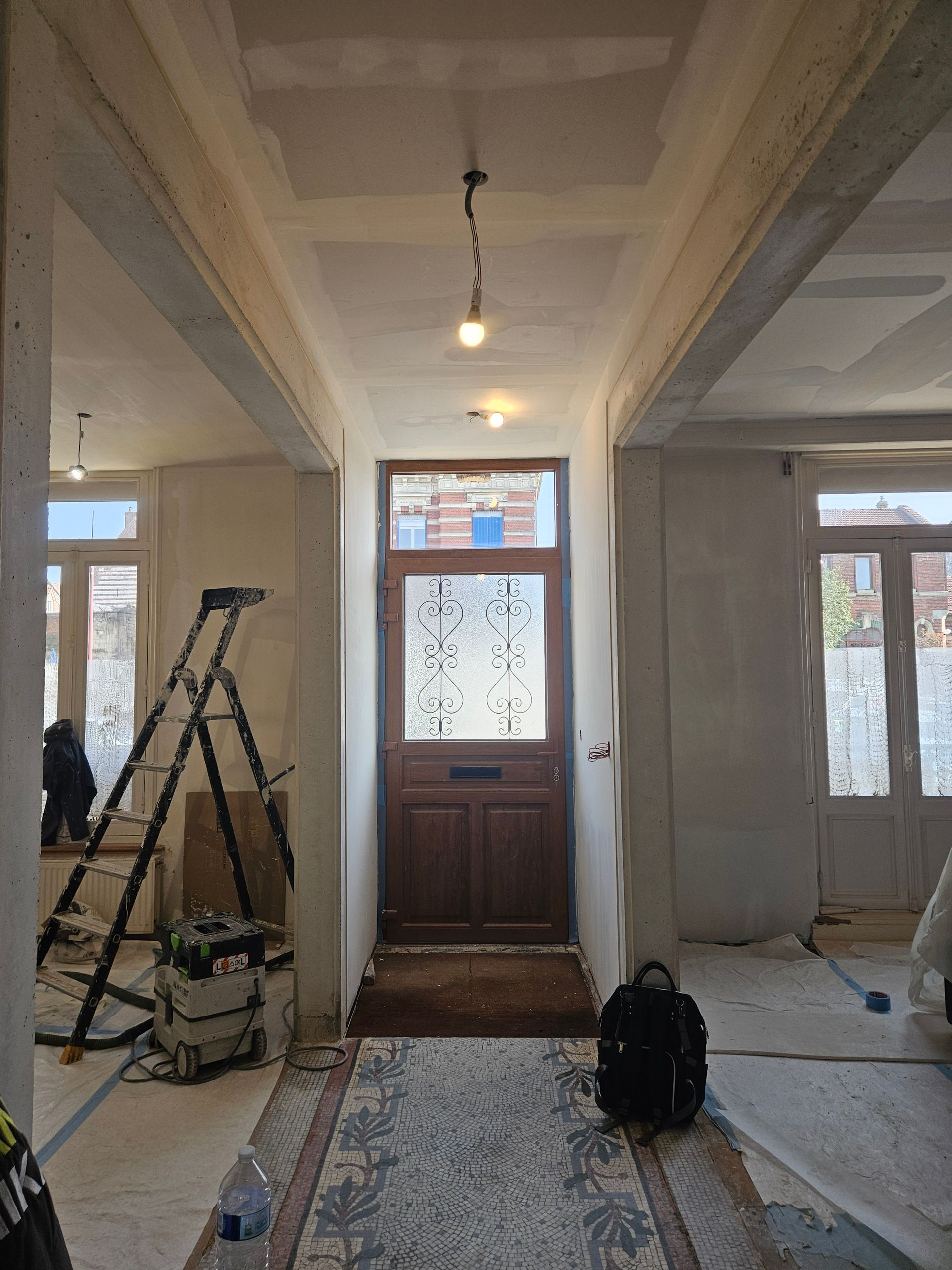 Couloir intérieur rénové menant à une porte d'entrée