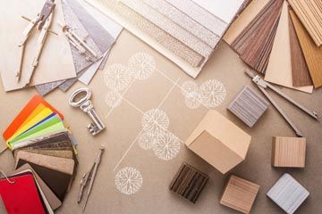 Échantillons de tissus et de bois, outils d'architecture et clé de détermination, disposés sur une surface.