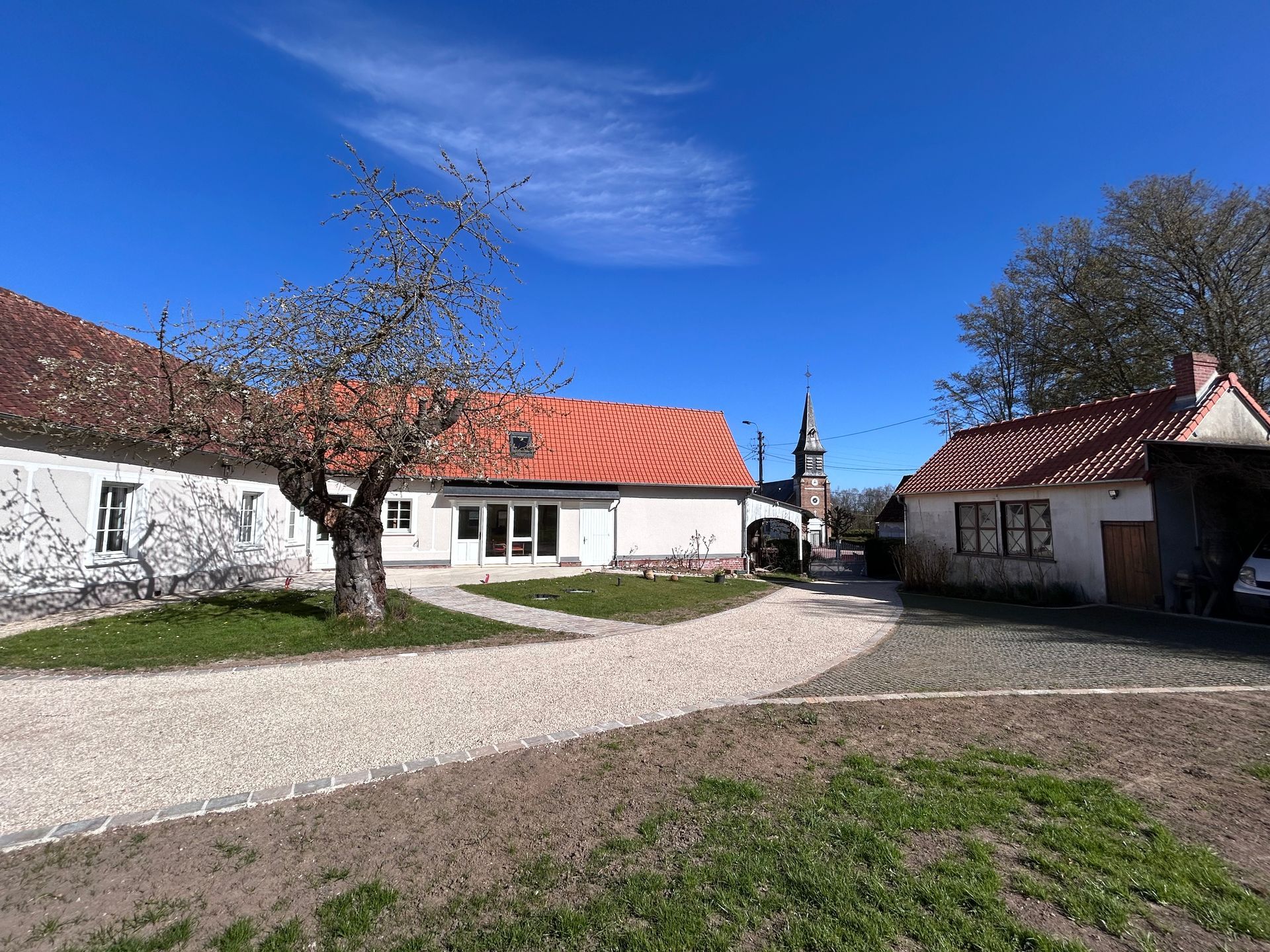 Maison blanche avec une allée en graviers