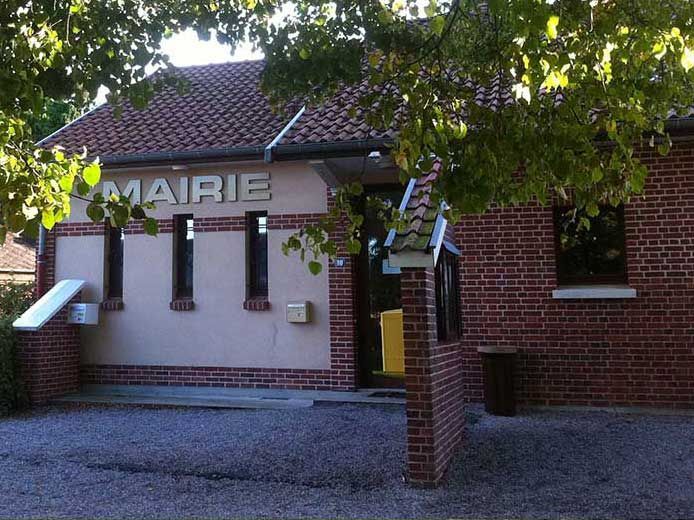 Bâtiment de la mairie (hôtel de ville) en briques rouges, façade beige, et l'inscription MAIRIE.