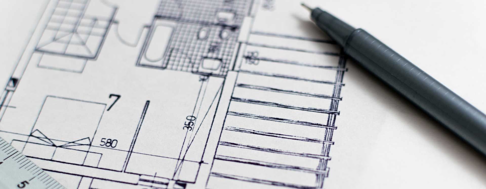 Plan architectural avec un stylo posé dessus.