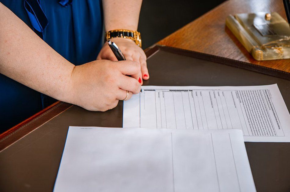 Mains de femme portant un stylo sur un document administratif